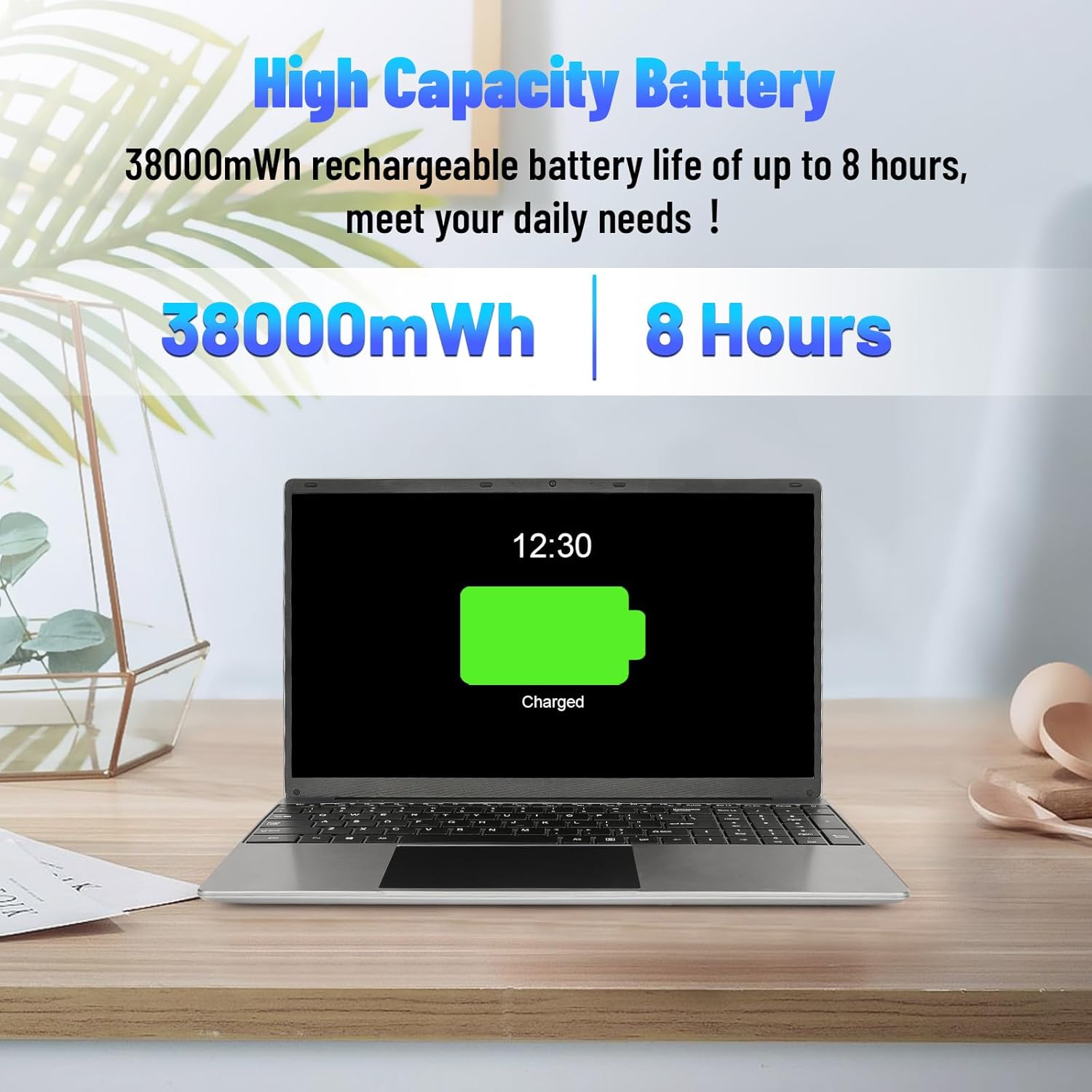 15.6-inch silver laptop on a desk, screen displaying charging at 12:30.